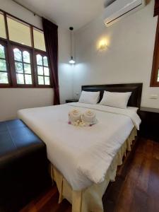 a bedroom with a large white bed with two candles on it at Sisina Resort and Spa in Prachuap Khiri Khan