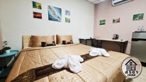 1 dormitorio con 1 cama con toallas en สรชา เพลส Soracha Place en Maha Sarakham