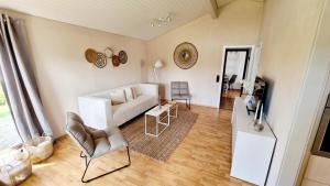 a living room with a white couch and a table at Ferienhaus Namenlos in Butjadingen