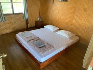 a bedroom with a large bed with two pillows on it at T & T Hostel Kanchanaburi in Kanchanaburi