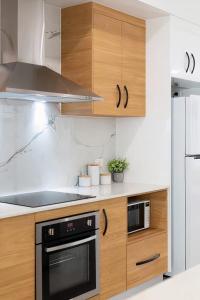 a kitchen with wooden cabinets and a stove at Coastal Villa in Edge Hill +23 photos