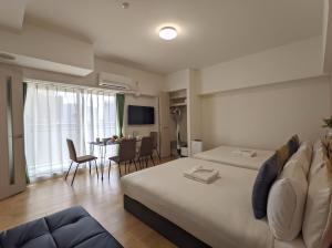 a hotel room with two beds and a dining room at ESLEAD HOTEL Namba South Ⅱ in Osaka