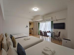 um quarto com 2 camas e uma sala de jantar em ESLEAD HOTEL Namba South Ⅱ em Osaka