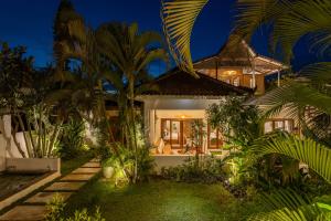 a villa with a garden at night at 5 Bedroom Entire Villa in Berawa Canggu in Dalung