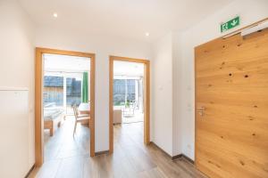 um corredor com uma porta de madeira e uma sala de estar em Appartementhaus Longa Stubn em Weisspriach