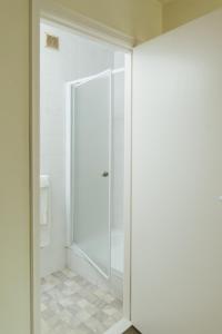 a bathroom with a shower and a glass door at Hotel Kempenrust in Kasterlee