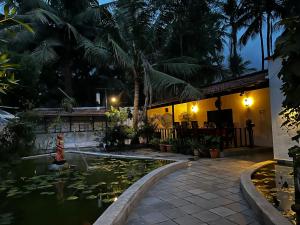 una piscina frente a una casa con un estanque koi en Mermaid Island Beach Resorts, en Pondicherry