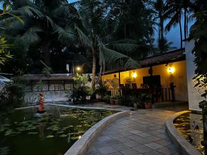 a pool in front of a house with a koi pond at Mermaid Island Beach Resorts in Puducherry