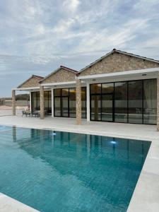 a house with a swimming pool in front of a building at Alreef farm in Ras al Khaimah