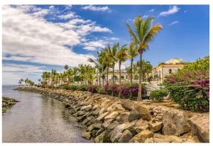a river with palm trees and houses on the shore at Gran Canaria Las Palmas Apartment in Mogán