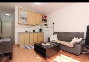 a living room with a couch and a kitchen at Gran Canaria Las Palmas Apartment in Mogán