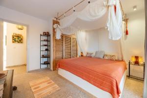 a bedroom with a bed with an orange and white bedspread at El Dorado in Es Pujols
