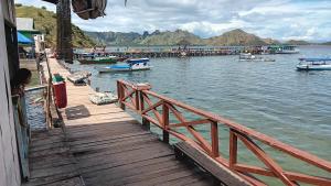 a dock with boats on a body of water at Khalisa Homestay in Komodo