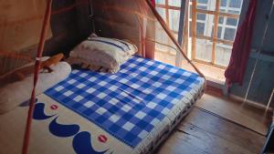Khalisa Homestay في Komodo: سرير عليه وسادتين في غرفة