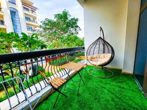 a balcony with two chairs and a bird cage at NA 303 Ansam Yas Island in Abu Dhabi