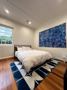 ein Schlafzimmer mit einem Bett und einem großen Wandgemälde in der Unterkunft Princes Cottage In Prahran, On Chapel St in Melbourne