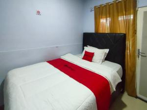 WatesにあるRedDoorz Syariah Near Stasiun Watesの白い大型ベッド(赤い毛布付)