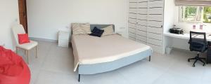 a bed in a room with a desk and a bed sidx sidx sidx at BANTAI White House in Nathon Bay