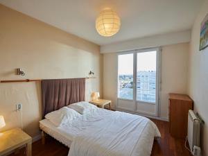 1 dormitorio con cama y ventana grande en Appartement Saint-Jean-de-Monts, 4 pièces, 7 personnes - FR-1-323-445, en Saint-Jean-de-Monts