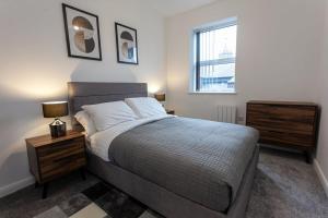 a bedroom with a bed with a nightstand and a window at Fantastic 1 Bedroom Apartment in Bolton in Bolton