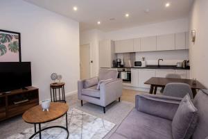 a living room with a couch and chairs and a kitchen at Modern 1 Bedroom Apartment in Bolton in Bolton
