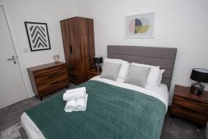 a bedroom with a large bed with a green blanket at Modern 1 Bedroom Apartment in Bolton in Bolton