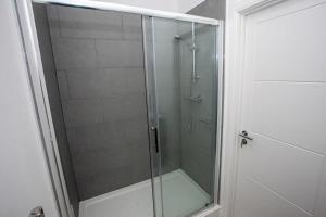 y baño con ducha y puerta de cristal. en Modern 1 Bedroom Apartment in Bolton, en Bolton