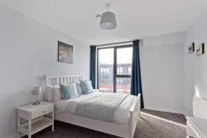 Habitación blanca con cama y ventana en Modern 1 Bedroom apartment in Central Brimingham, en Birmingham