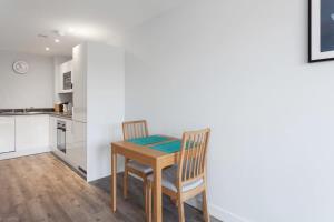 una pequeña cocina con mesa y 2 sillas en Modern 1 Bedroom apartment in Central Brimingham, en Birmingham