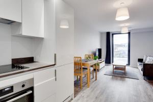 a kitchen and living room with a table and chairs at Modern 1 Bedroom Flat In Central Birmingham in Birmingham