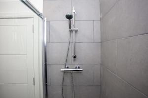 a shower with a shower head and a shower at Lovely Open Plan 1 Bedroom Apartment in Bolton in Bolton