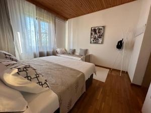 a bedroom with a bed and a couch and a window at Sunny Hill Apartment in Ilirska Bistrica