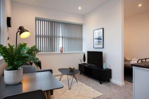 a living room with a couch and a television at Modern 1 Bedroom Apartment in Bolton in Bolton