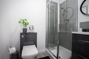 a bathroom with a toilet and a glass shower at Modern 1 Bedroom Apartment in Bolton in Bolton