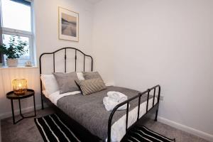 a bedroom with a bed with a black bed frame at Modern 1 Bedroom Apartment in Bolton in Bolton