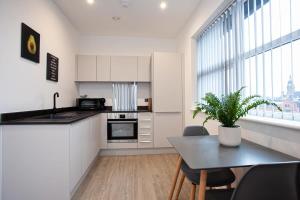 uma cozinha com uma mesa com uma planta em Modern 1 Bedroom Apartment in Bolton em Bolton