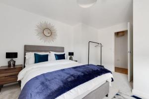 a bedroom with a large bed with blue pillows at 1 Bed Modern Apartment in a Converted Mill in Leeds