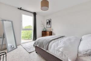 a white bedroom with a bed and a mirror at 1 Bed Modern Apartment in a Converted Mill in Leeds