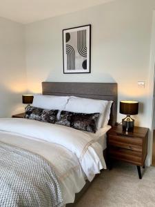 a bedroom with a large bed with two lamps on a table at 1 Bed Modern Apartment in a Converted Mill in Leeds