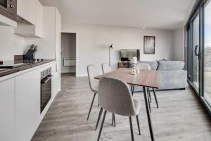 a kitchen and living room with a table and chairs at Modern 2 Bedroom Apartment in Central Birmingham in Birmingham