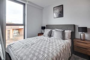 a bedroom with a large bed and a large window at Modern 2 Bedroom Apartment in Central Birmingham in Birmingham