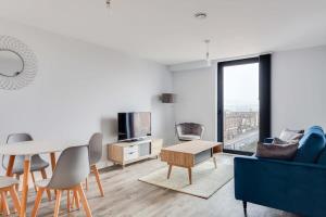 a living room with a blue couch and a table at Stunning 2br Flat in the Centre of Birmingham in Birmingham