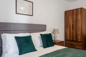 1 dormitorio con 1 cama con almohadas verdes y blancas en Modern & Stylish 1Bed Flat in Central Birmingham, en Birmingham