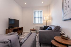 a living room with a couch and a tv at Modern 1 Bedroom Apartment in Bolton in Bolton