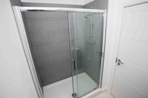 a shower with a glass door in a bathroom at Modern & Stylish 1 Bedroom Apartment in Bolton in Bolton