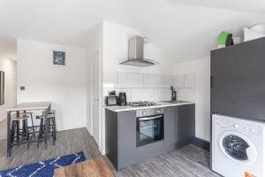 a small kitchen with a stove and a refrigerator at Lovely 2 Bed apartment close to city centre in Bradford