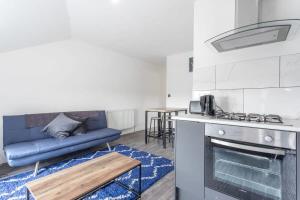 a kitchen and living room with a couch and a stove at Lovely 2 Bed apartment close to city centre in Bradford