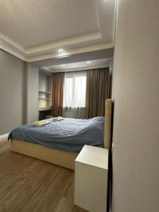 a small bedroom with a bed and a window at Your home away from home. in Bishkek