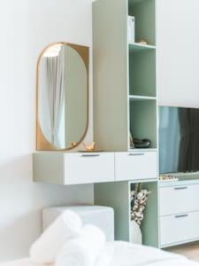 a bedroom with a mirror and a white cabinet at Cozy Chic Studio with Balcony The Greens Dubai in Dubai