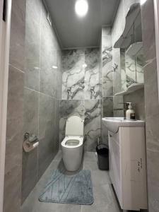 a bathroom with a toilet and a sink at Your home away from home. in Bishkek